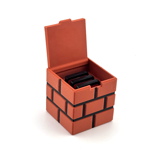 Open orange brick-style magnetic game cartridge holder with three compatible game cartridges
