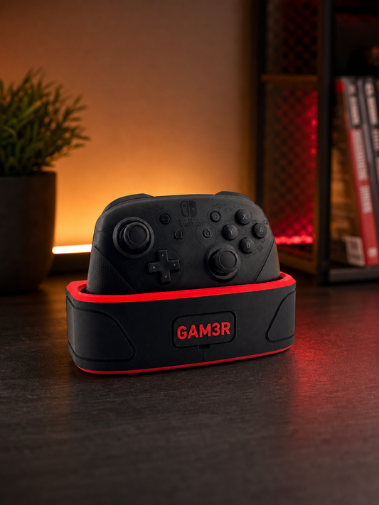 Black Nintendo Switch Pro Controller in a black-and-red personalized GAM3R charging dock on an ambient gaming shelf