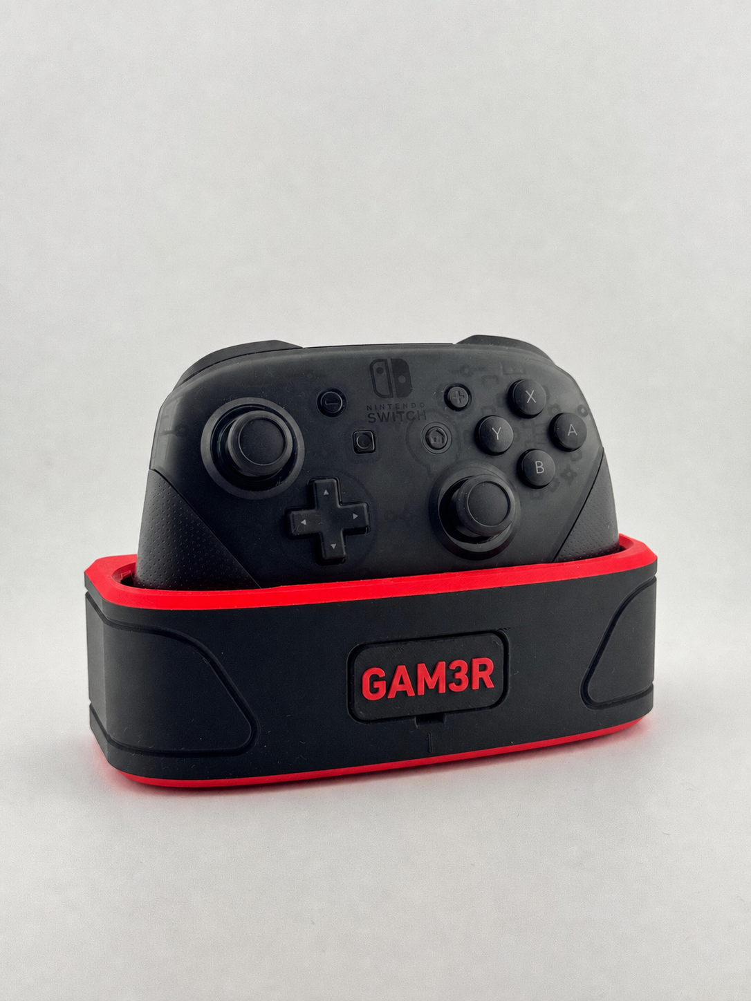 Nintendo Switch Pro Controller fully visible in a black-and-red personalized controller dock with GAM3R nameplate